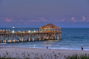 A pier extending into the ocean with a thatched-roof structure at the end. - Heated Pool-Incredible View- (Cocoa Beach)