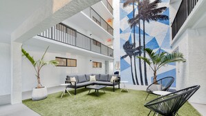 Eine moderne Lounge-Ecke im Freien mit einem Ecksofa, einem Couchtisch und zwei Stühlen.