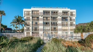Ein mehrstöckiges Hotel mit Balkonen, einem Pool und einem Weg zum Eingang.
