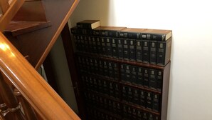 Eine Holztreppe mit einer Bücherwand voller Fachbücher für Recht.