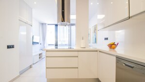 Una cocina moderna con armarios blancos, una isla central y lavavajillas.