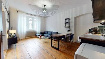 Een moderne woonkamer met een bank, eettafel en een keukenhoek.