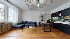 Un espace de vie moderne comprenant un canapé, une table à manger et un coin cuisine.