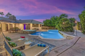 Una propiedad residencial con piscina, mobiliario de patio y un jardín bien cuidado.