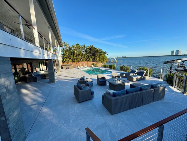 A rooftop pool area with outdoor seating and a view of the water.