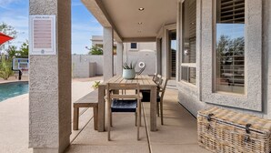 A covered patio area with a pool table, chairs, and a wicker basket. - Incredible golf course views with modern, southwest inspired decor (Mesa)