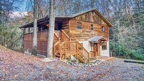 Eine rustikale Holzhütte mit Veranda und einer Treppe zum Eingang.