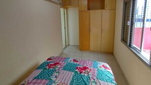 A bedroom with a bed, a wardrobe, and a window.