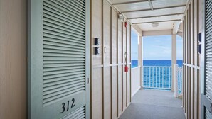 A corridor with a view of the sea, a balcony, and a door labeled 312. - Hale Kona Kai 312 - Absolute Oceanfront Condo with wraparound lanai (Kailua Kona)