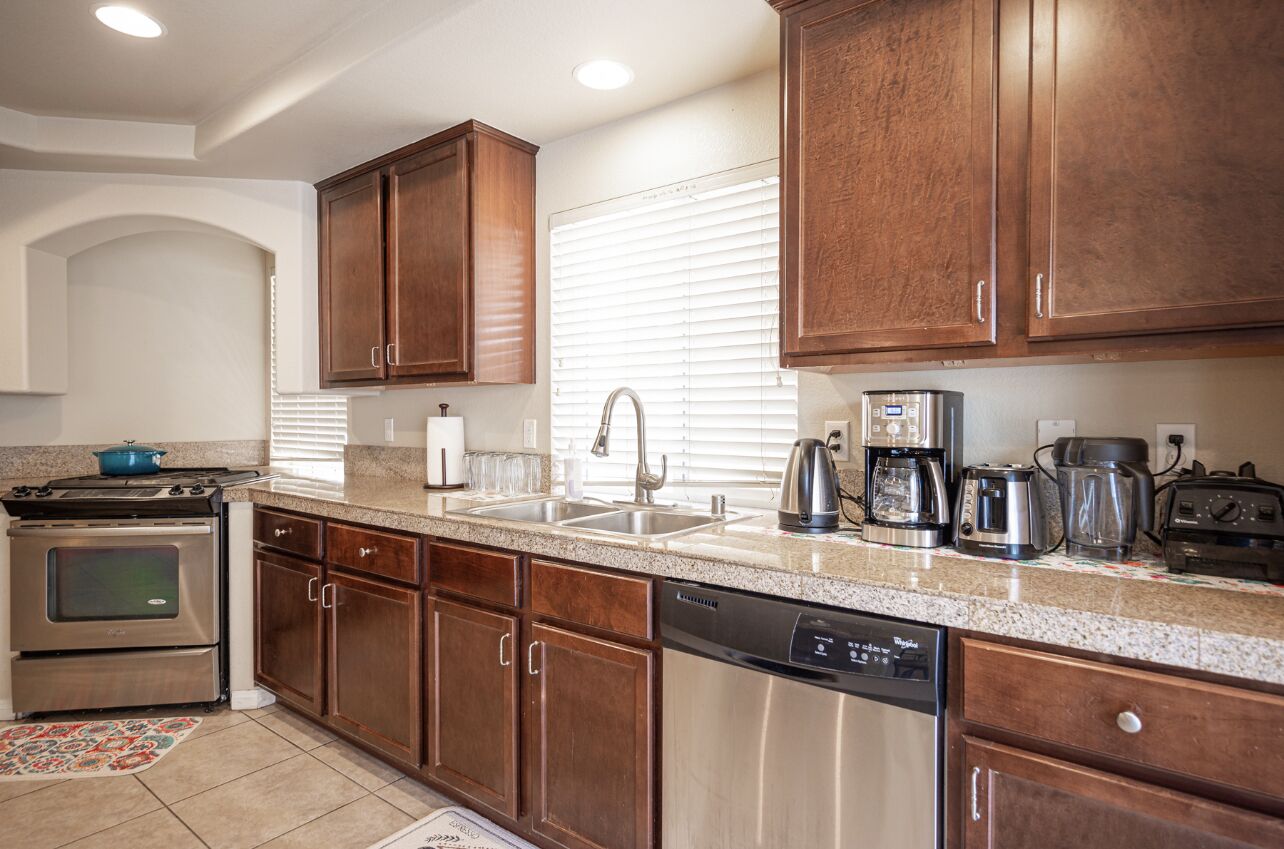 A kitchen with wooden cabinets, stainless steel appliances, and a granite countertop.
