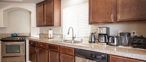 A kitchen with wooden cabinets, stainless steel appliances, and a granite countertop.