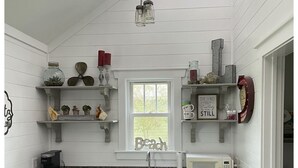 A kitchen with white cabinetry, a granite countertop, a sink, a microwave, a refrigerator, and a window with a view of the outdoors. - Walking distance to Downtown Beaufort, NC. Short drive to several beaches. (Beaufort)