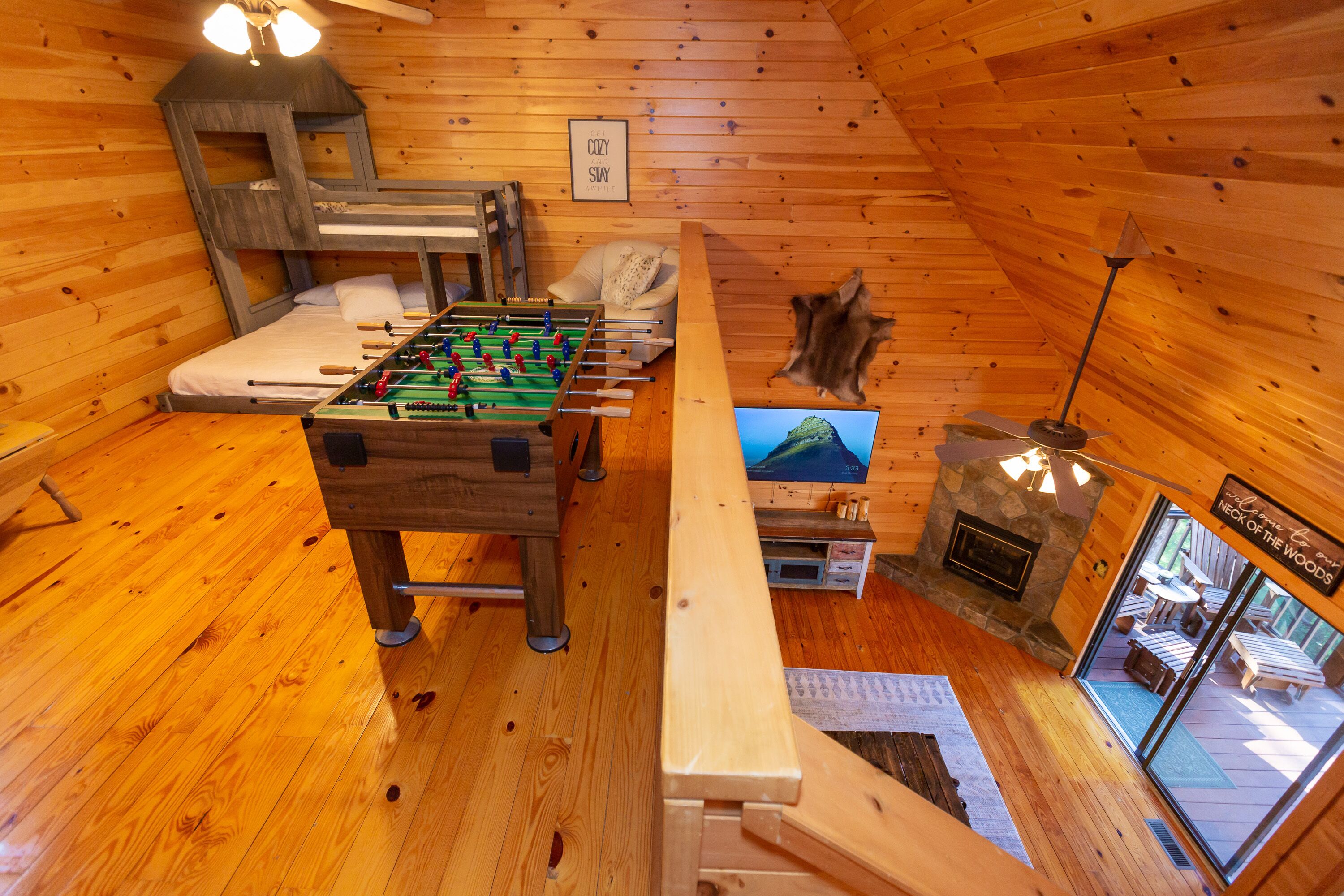 Una habitación acogedora con mesa de fútbol, cama, chimenea y vistas al exterior.