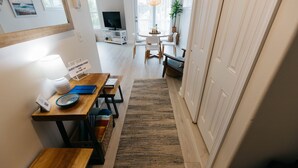 Une cuisine moderne avec un coin repas, des meubles en bois et un téléviseur.