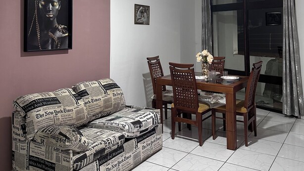 A dining area with a table, chairs, and a ceiling fan. - Apartment in the heart's corner of the historic center (aparecida sp)