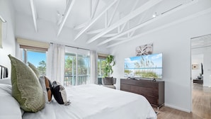 A modern bedroom with a large bed, a TV, and a balcony with a view of the outdoors. - 🌴Beachside Escape Private Modern Heated Pool - Vacation Getaway Gulf Shores🌴 (Gulf Shores)