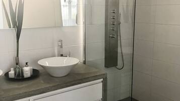 Een douche, handdoeken, zeep, toiletpapier