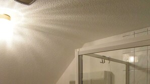 A bathroom with a toilet, sink, and glass-enclosed shower. - Apartment Pier 4 - Holiday apartments Hagen (Zinnowitz)