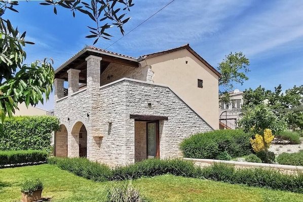 A stone building with a flat roof and a small balcony.