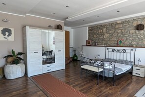 Une chambre à coucher avec un lit, une table de chevet et un grand miroir.