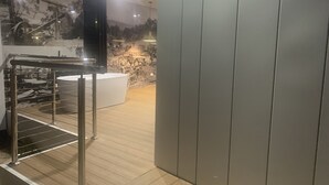 A modern bathroom with a bathtub, a shower area, and a wooden floor. - Ironbark Luxury Retreat at Softfoot Alpaca Farm in Victor Harbor (Hindmarsh Valley)