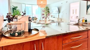 A modern kitchen with wooden cabinets, a built-in espresso machine, and a glass countertop. - Partial Ocean 3 Beds -1 bath  Brickell @ownpm10 (Miami)