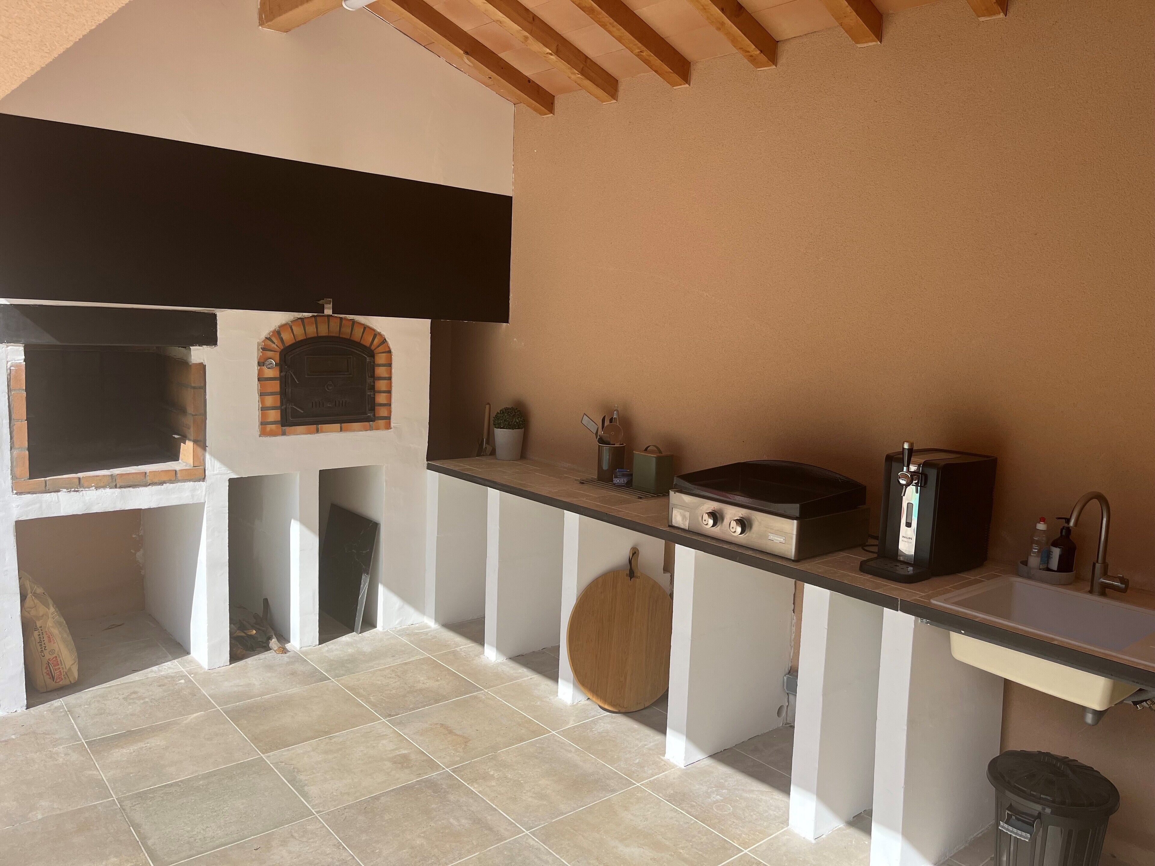 Una cocina con horno empotrado, un lavamanos y una estufa.