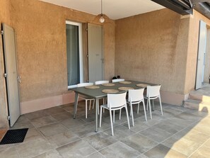 Ein Essbereich mit Tisch, Stühlen, einer Hängelampe und einer Tür.