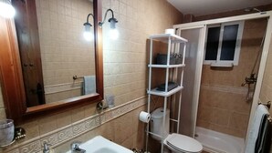 A bathroom with a sink, mirror, toilet, and shower. - Spacious Apartment (Armilla)