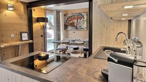 Una cocina moderna con una isla central, electrodomésticos de acero inoxidable y vista al área de comedor.