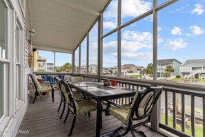 Enjoy a peaceful outdoor space with a deck, table, and chairs, offering a view of the surrounding neighborhood.