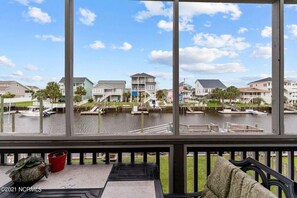 Enjoy the serene marina views from this room's large windows, featuring a seating area with a bench and table.