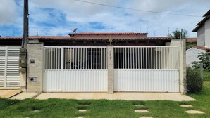 A gated residential property with a brick wall, a metal gate, and a tiled roof.