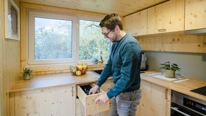 Une cuisine en bois avec une fenêtre, un évier et une cuisinière.