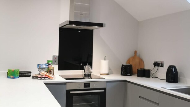 A modern kitchen with a built-in oven, a stovetop, and a range hood.