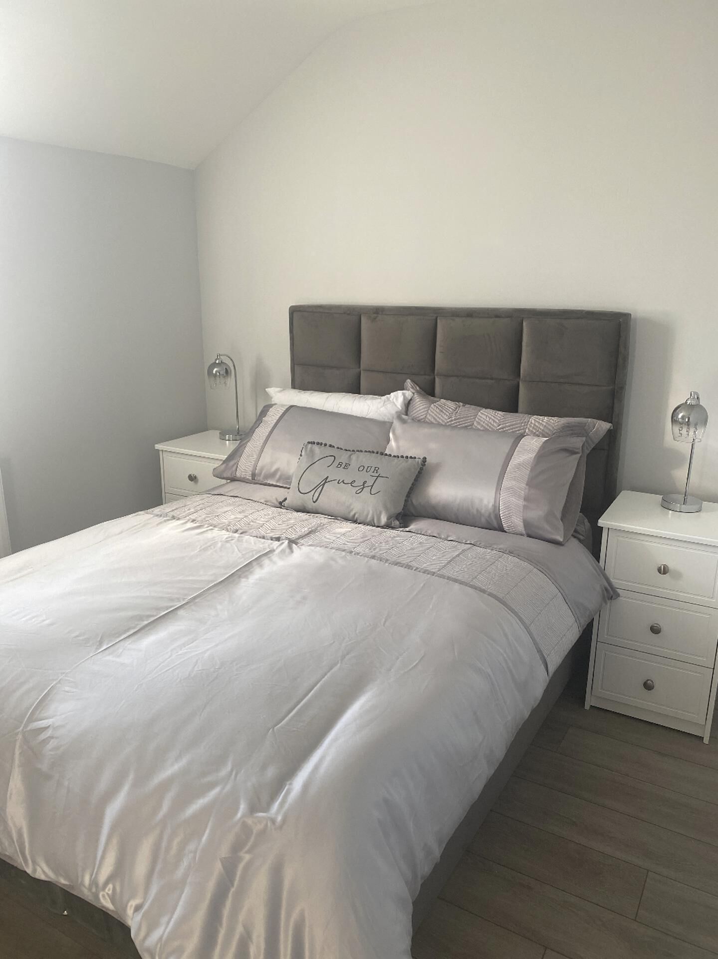 Une chambre à coucher avec un lit, des tables de chevet et une tête de lit.