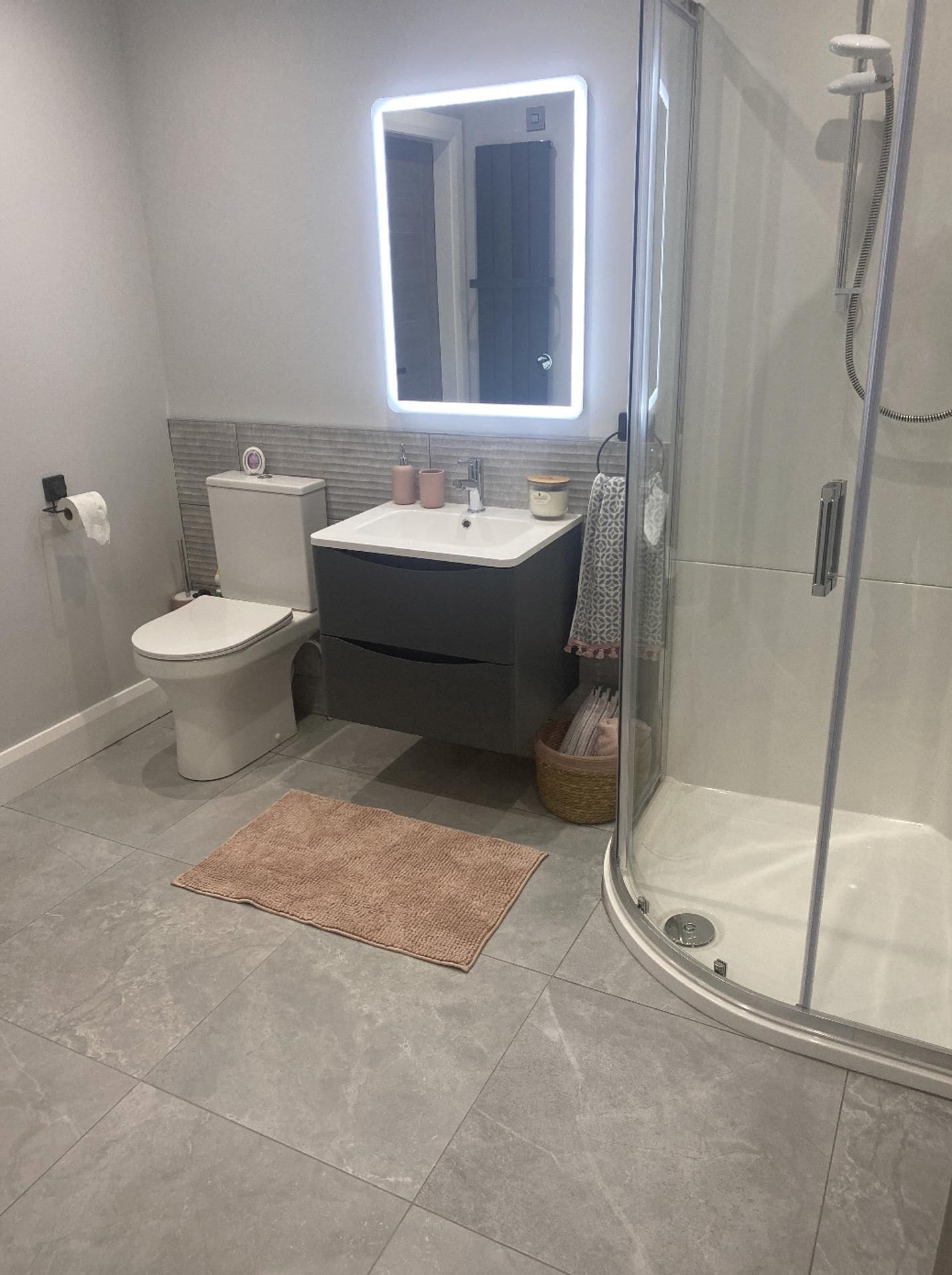 A modern bathroom with a toilet, sink, and shower.