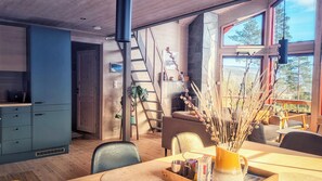 A modern interior with a dining area, a staircase, and a view of the outdoors. - Vacation Home in Vrådal, Norway: Large Terrace, Sauna, Quiet Location, and Close to Downtown (Vestfold og Telemark)
