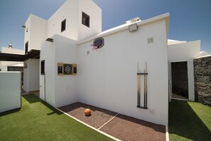 A modern white building with a basketball hoop and dartboard. - Private pool and hot tub, mountain and sea views, pool table, children’s park. (Playa Blanca)