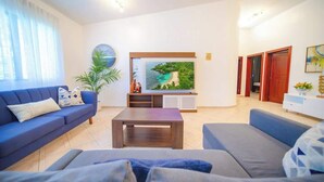Ein modernes Wohnzimmer mit einer Couch, einem Couchtisch und einem flachbildfernseher an der Wand.