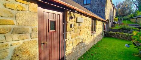 A stone cottage with a wooden door and a small window.