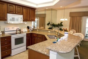Enjoy cooking in this well-equipped kitchen with a microwave, stove, and sink, plus a dining area with a table and chairs.