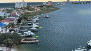 Una marina con imbarcazioni ormeggiate, un grande hotel e uno skyline costiero sullo sfondo.