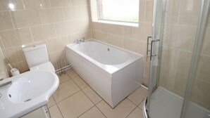 A bathroom with a bathtub, toilet, and sink. - Inviting 5-bed House in Stockport Bramhall (Stockport)