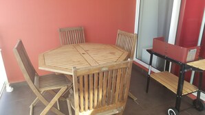 Una taula de fusta i quatre caires en una habitació amb una paret vermella i una finestra.