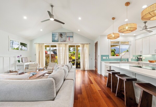 A spacious living area with a large sofa, a dining table, and a kitchen with a view.