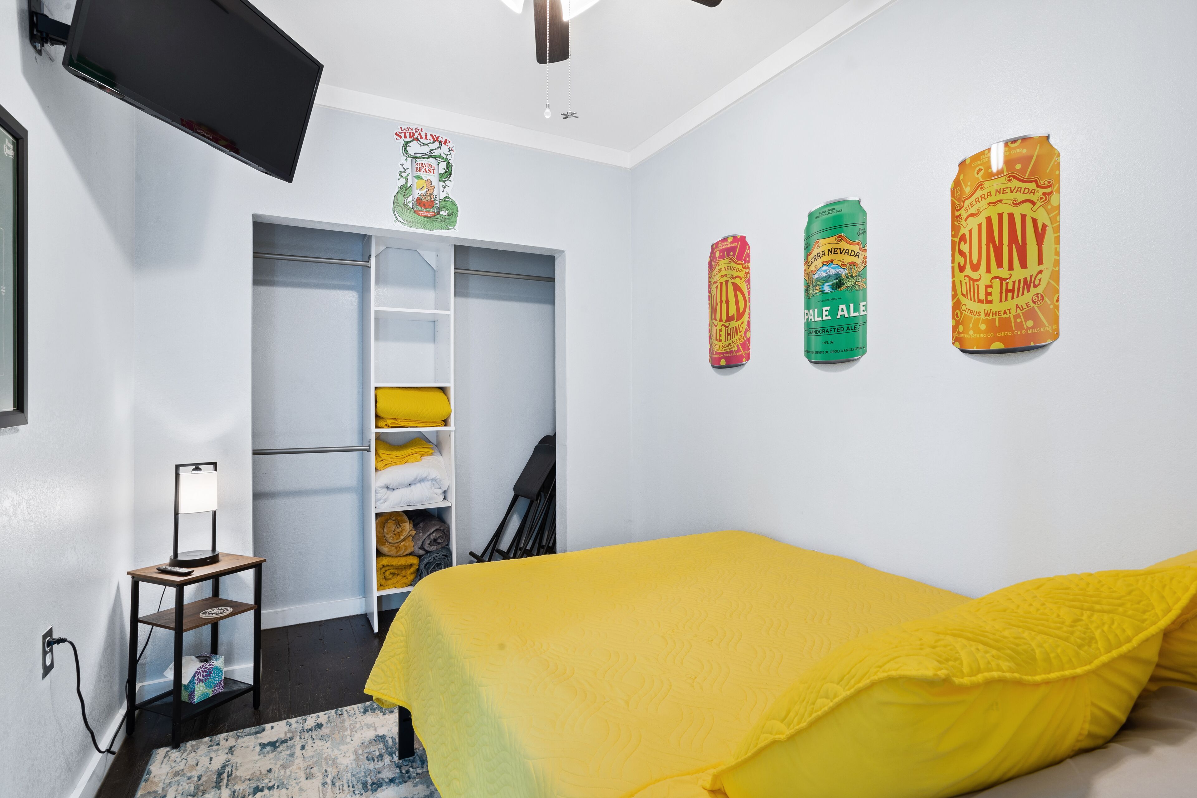Un dormitorio con una cama, un armario y una estantería con objetos.
