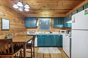 Cozy kitchen with a dining table, microwave, toaster, and refrigerator, perfect for meal preparation and dining.