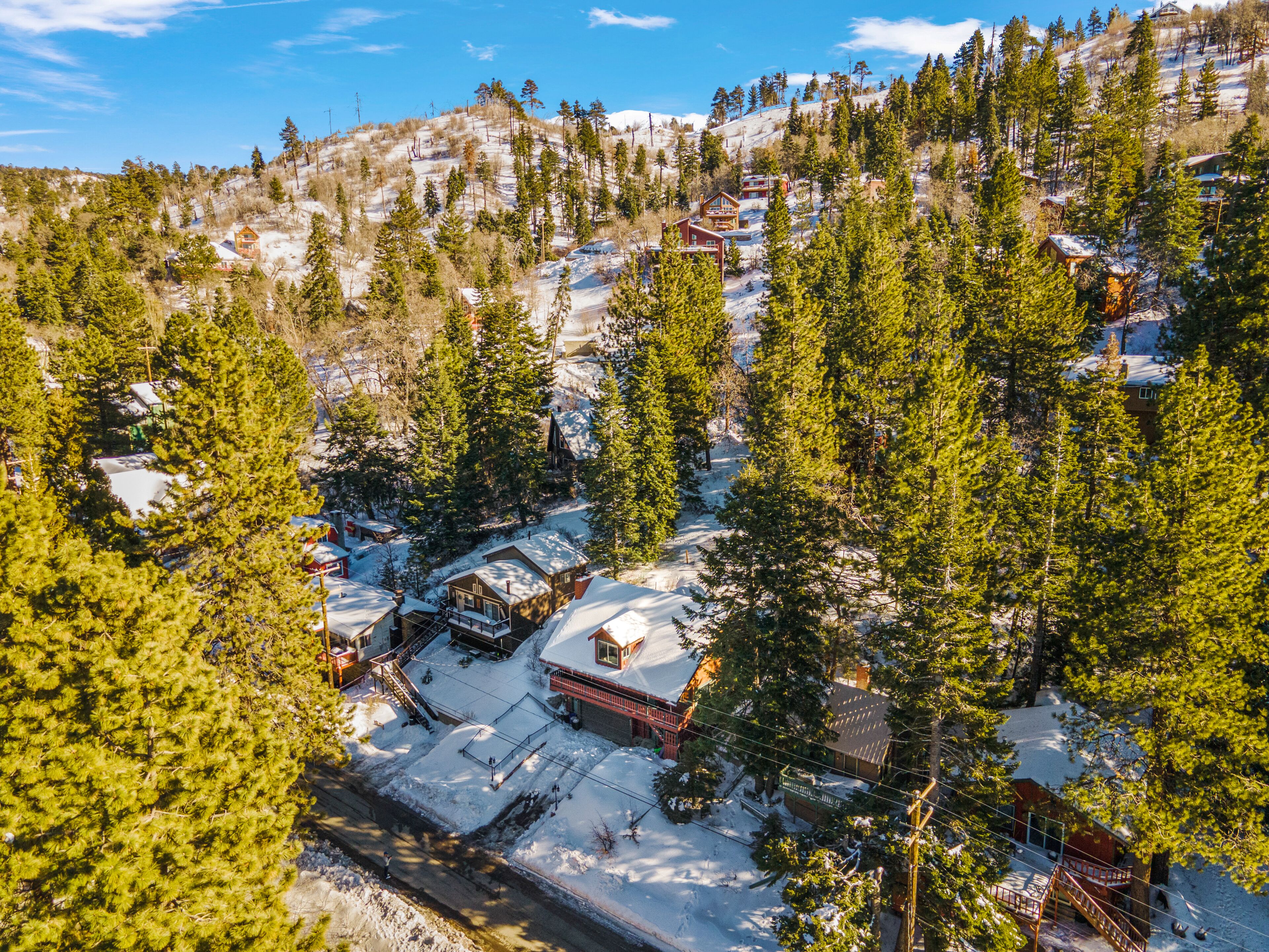 A snow-covered mountain village with wooden cabins and a ski lift.