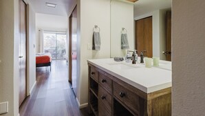 A modern bathroom with a large mirror, wooden vanity, and a window providing natural light. - Tennis & Pickle ball courts, Golf, Hiking (Sedona)